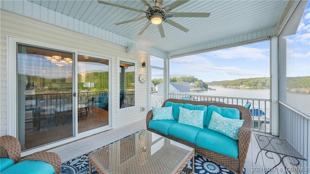 sunroom / solarium featuring a wealth of natural light, a water view, and ceiling fan