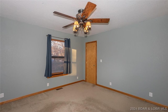 carpeted spare room featuring a textured ceiling and ceiling fan