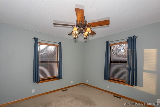 unfurnished room with carpet flooring, ceiling fan, and a textured ceiling