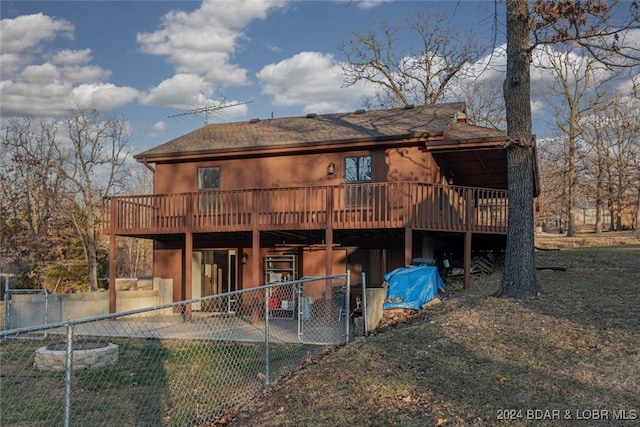 back of house with a lawn and a deck