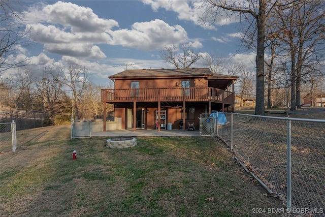 back of property with a patio area, a yard, an outdoor fire pit, and a wooden deck