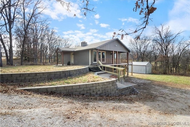 view of front of home with covered porch and a shed