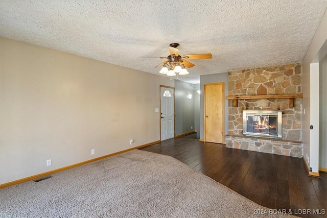 unfurnished living room featuring a fireplace, a textured ceiling, and dark hardwood / wood-style floors