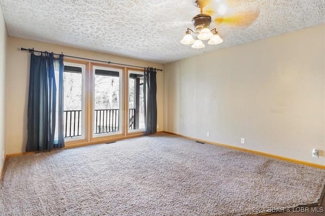 carpeted spare room with a textured ceiling and ceiling fan