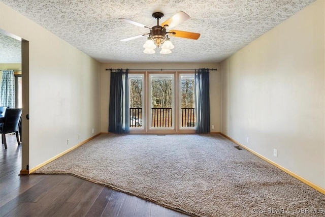 empty room featuring a textured ceiling, dark hardwood / wood-style flooring, and ceiling fan