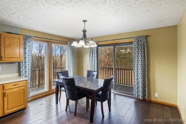 dining space with dark hardwood / wood-style flooring, a textured ceiling, and an inviting chandelier