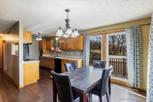 dining area featuring a textured ceiling, ceiling fan with notable chandelier, dark wood-type flooring, and sink