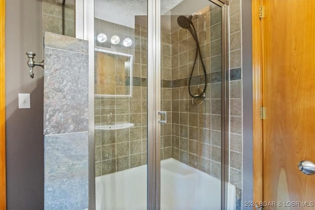 bathroom with a textured ceiling and an enclosed shower