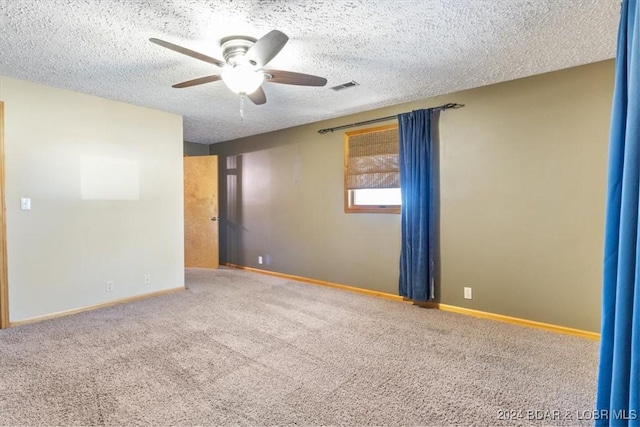 carpeted spare room with ceiling fan and a textured ceiling