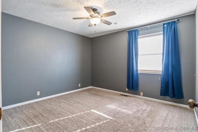 spare room featuring ceiling fan, carpet floors, and a textured ceiling