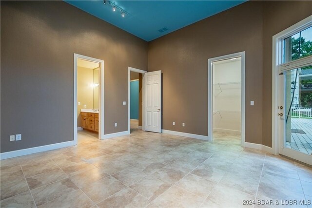 825 Grand View Dr, Porto Cima, MO 65079 - unfurnished bedroom with a spacious closet, track lighting, a closet, and connected bathroom