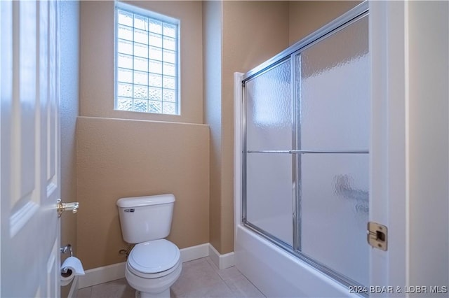 bathroom with tile patterned flooring, toilet, and enclosed tub / shower combo