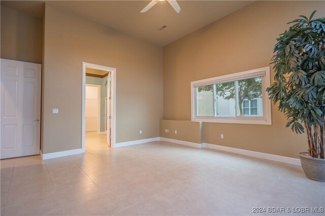825 Grand View Dr, Porto Cima, MO 65079 - empty room featuring a ceiling fan, light tile patterned floors, and high vaulted ceiling
