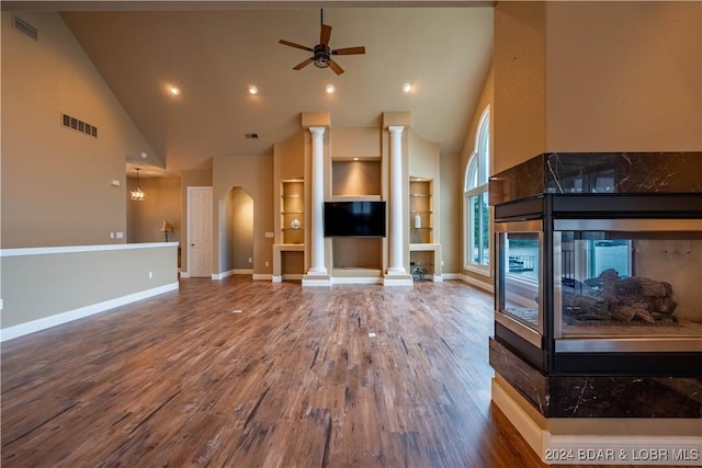 825 Grand View Dr, Porto Cima, MO 65079 - unfurnished living room featuring high vaulted ceiling, a ceiling fan, built in shelves, wood finished floors, and a multi sided fireplace