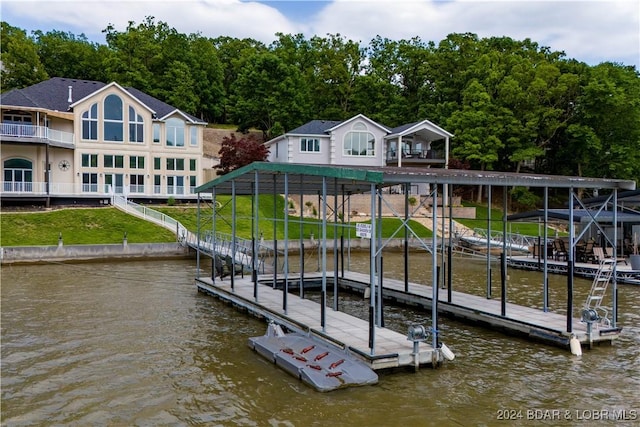 view of dock with a lawn and a water view