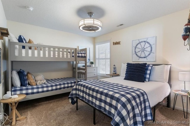 bedroom with a textured ceiling and carpet floors