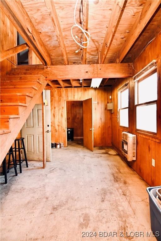 interior space featuring heating unit and wooden walls