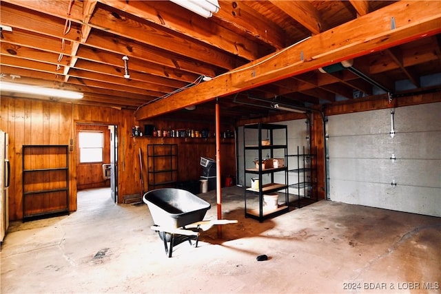 garage with wood walls and stainless steel refrigerator