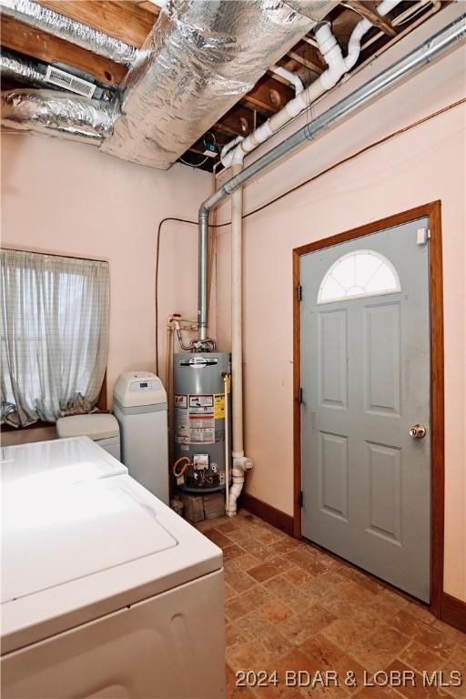 washroom with water heater and washer and clothes dryer