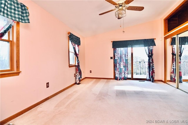 unfurnished room featuring vaulted ceiling, ceiling fan, and a healthy amount of sunlight