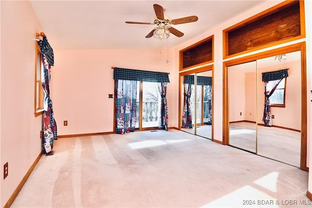 carpeted spare room with ceiling fan and vaulted ceiling