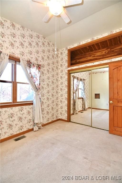 26 Gap Rd, Tunas, MO 65764 - unfurnished bedroom with light colored carpet, multiple windows, wallpapered walls, baseboards, and a ceiling fan