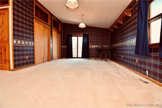 carpeted empty room featuring vaulted ceiling