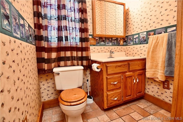26 Gap Rd, Tunas, MO 65764 - bathroom with wallpapered walls, toilet, vanity, stone finish floors, and baseboards