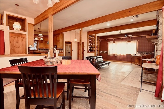 dining room with beam ceiling, light hardwood / wood-style flooring, and sink