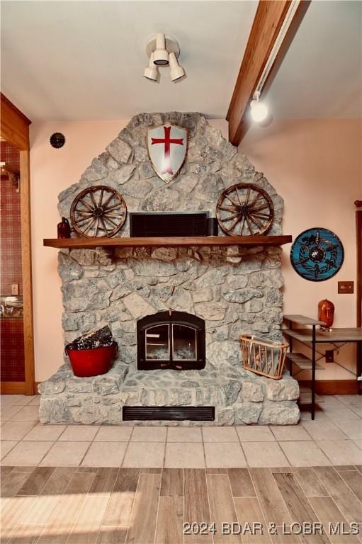 interior details with a fireplace, beam ceiling, and wood-type flooring