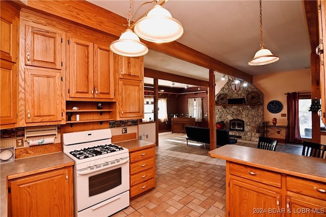 kitchen with a fireplace, decorative light fixtures, white gas range, and beamed ceiling