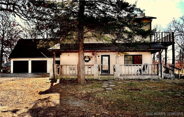 view of front of home featuring covered porch, a garage, and an outdoor structure