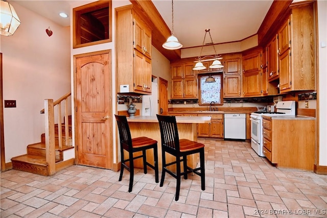 kitchen with sink, kitchen peninsula, pendant lighting, white appliances, and a breakfast bar