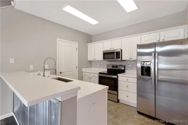 kitchen featuring kitchen peninsula, stainless steel appliances, white cabinets, and sink