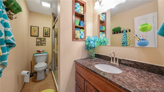 bathroom with tile patterned floors, vanity, toilet, and walk in shower