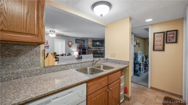 kitchen featuring backsplash, ceiling fan, sink, and a textured ceiling