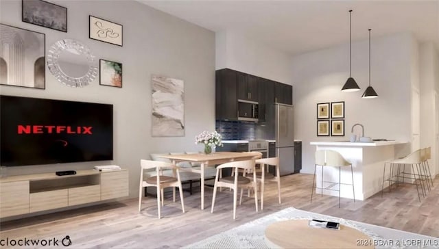 dining space with a high ceiling and light wood-style floors