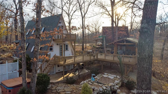 rear view of property with a jacuzzi, a balcony, and a patio area