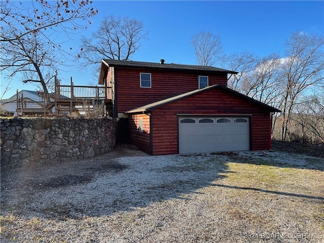 view of property exterior with a garage and a deck