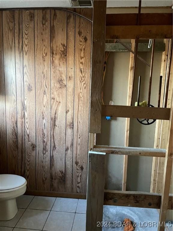 interior space with toilet and wooden walls