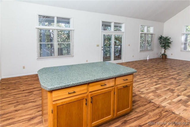 kitchen featuring lofted ceiling, a kitchen island, and light wood-type flooring