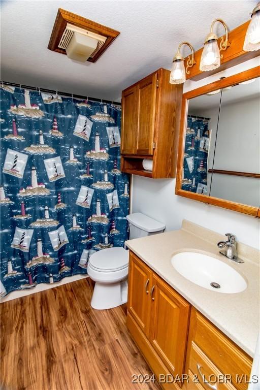 bathroom featuring vanity, hardwood / wood-style floors, and toilet