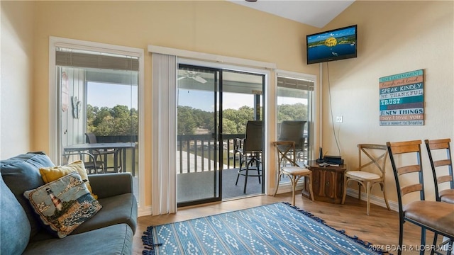 doorway featuring baseboards, wood finished floors, and vaulted ceiling