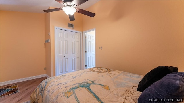 bedroom featuring visible vents, ceiling fan, baseboards, wood finished floors, and a closet