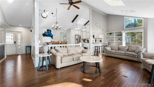 living room with ceiling fan with notable chandelier, dark hardwood / wood-style flooring, a skylight, and high vaulted ceiling