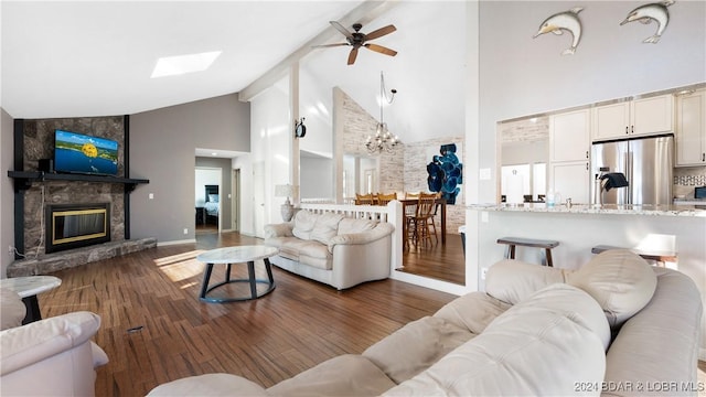 living room with dark hardwood / wood-style flooring, ceiling fan with notable chandelier, beam ceiling, high vaulted ceiling, and a fireplace