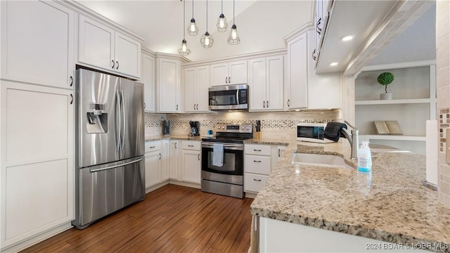 kitchen with pendant lighting, dark wood-type flooring, light stone counters, white cabinetry, and stainless steel appliances