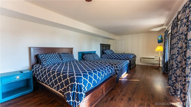 bedroom with a wall mounted air conditioner and dark hardwood / wood-style floors