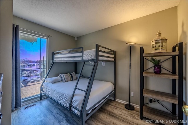 bedroom with wood-type flooring and a textured ceiling