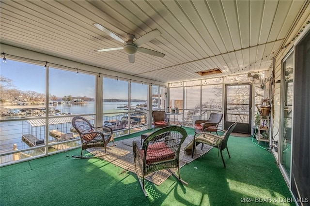 unfurnished sunroom with a water view and ceiling fan